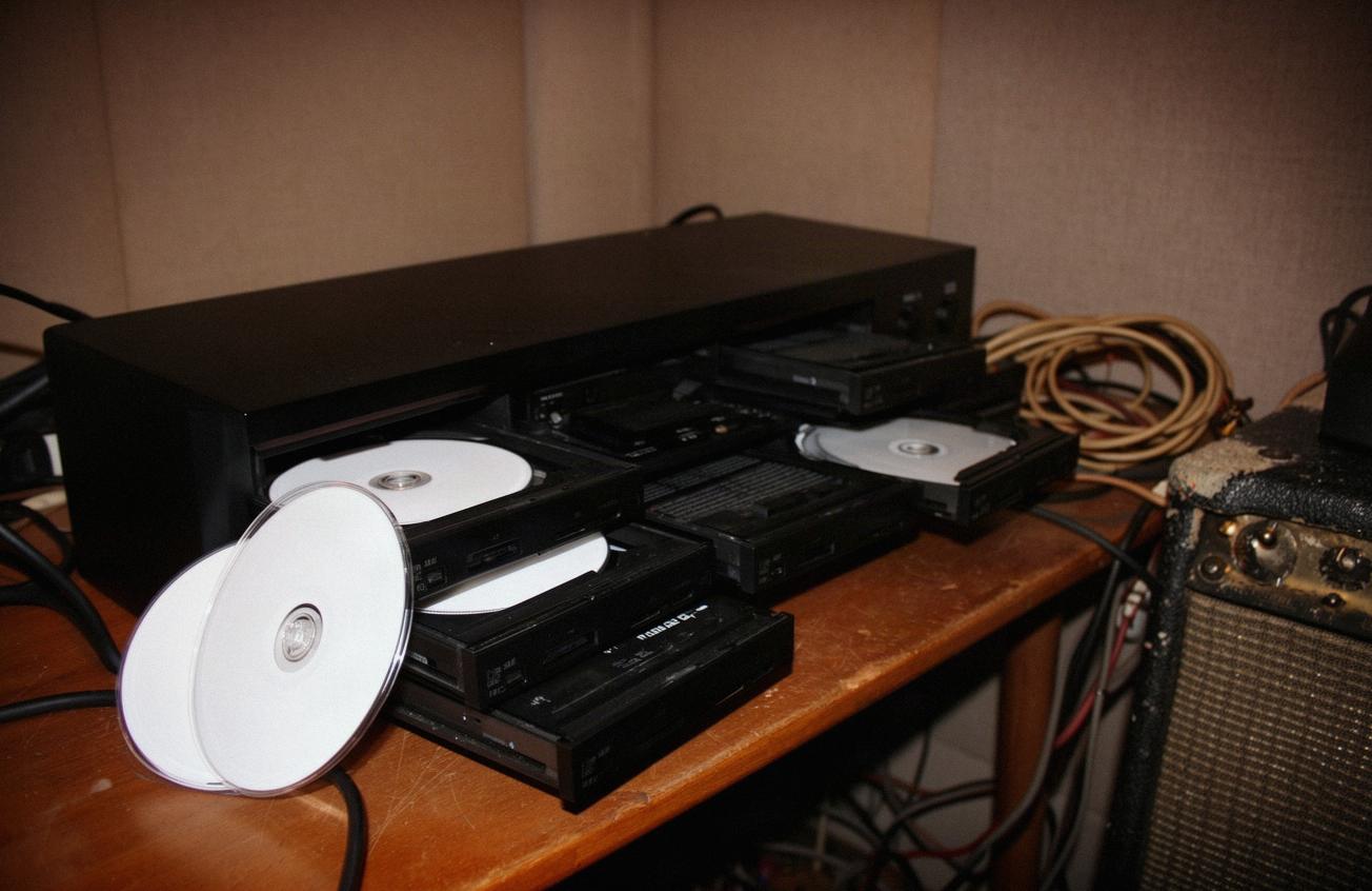 Duplikator płyt z otwartymi szufladami i szpindel czystych płyt CD-R na biurku w sali prób